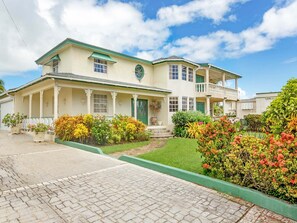 A two-story house with a balcony, a front porch, and a well-maintained garden. - Ocean View by Bluescape (Belair)