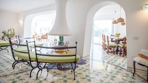 Un comedor con una mesa redonda, sillas y una lámpara decorativa.