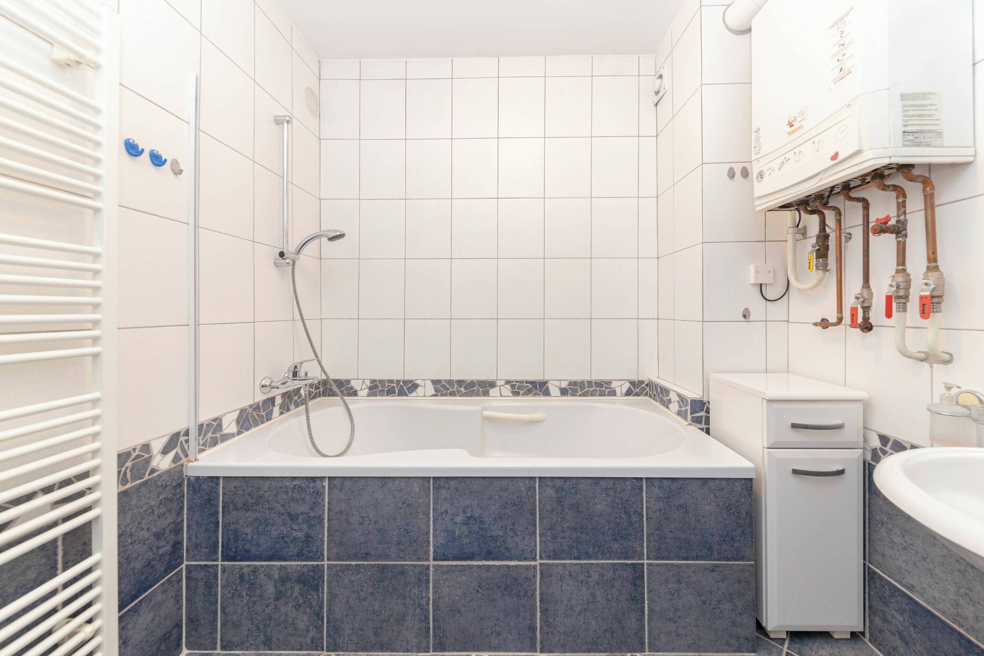 Un baño con bañera, ducha e inodoro.