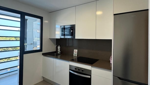 A modern kitchen with a stainless steel refrigerator, a microwave, and a dishwasher. - Mars Suites Zapata  (Madrid)
