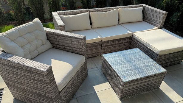 A wicker sectional sofa with cushioned seats and a matching ottoman.