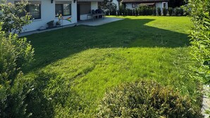 A modern house with a well-maintained lawn and a clear sky.
