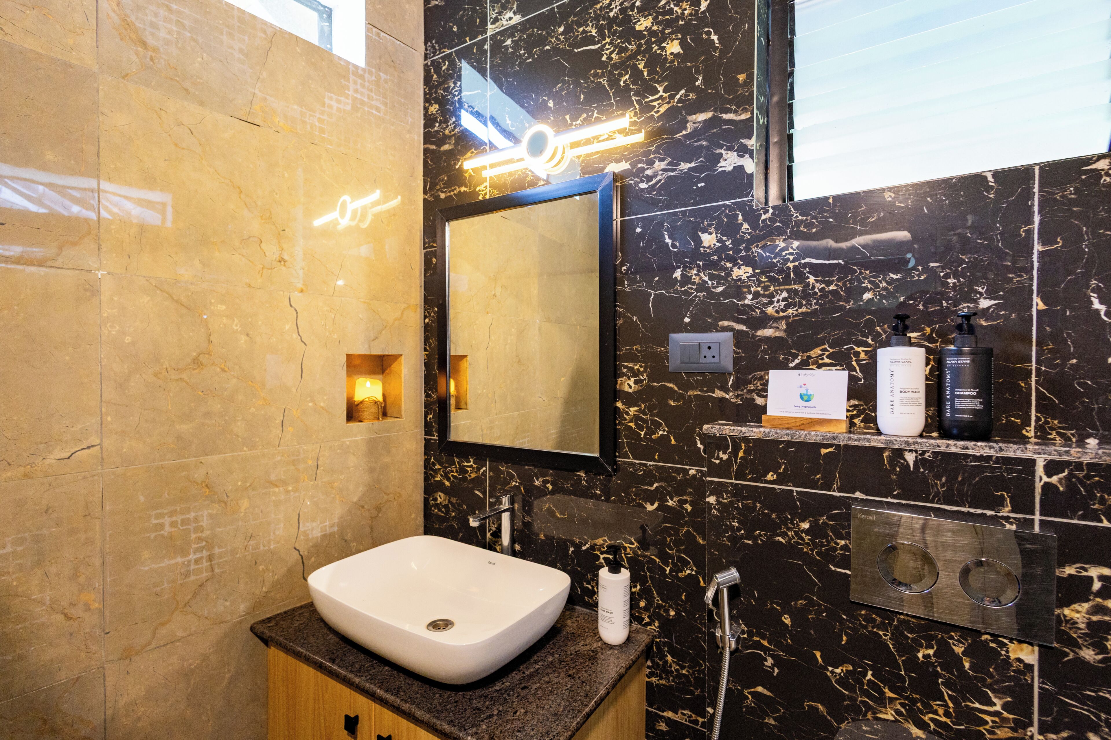 Une salle de bain moderne avec un lavabo en marbre, un miroir et un panneau de commande pour la douche.