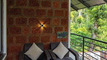 Un rincón acogedor con pared de ladrillo, una mesa con una cesta de aperitivos y vistas al verdor.