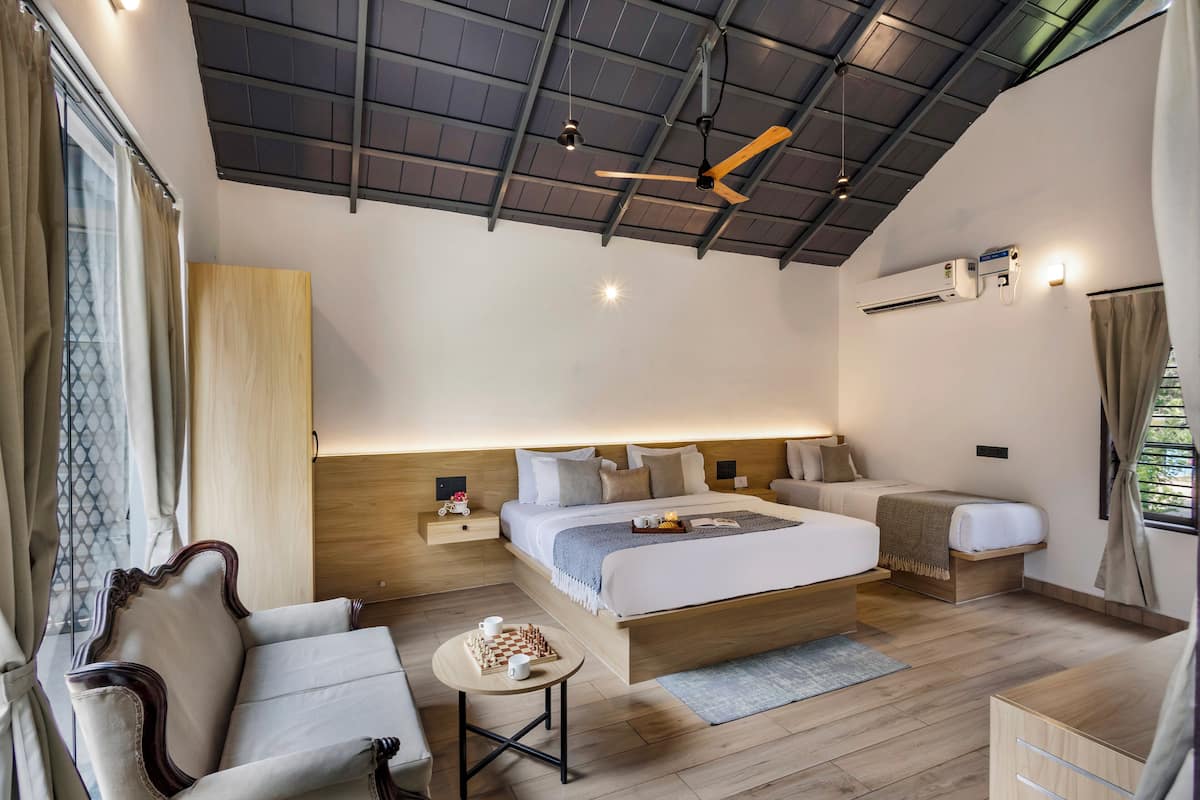 A modern bedroom with a large bed, bedside tables, a desk, a chair, and a ceiling fan.