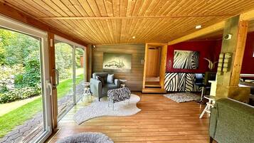 Ein modernes Interieur mit Holzböden, einem Sofa, einem Hocker mit ZEBRA-Muster und einem Bild an der Wand.
