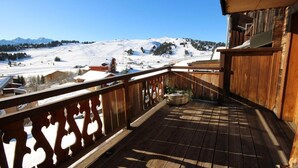 A wooden balcony with a view of a snowy mountain landscape. - 50m from ski slopes, 1st floor, terrace, fireplace or stove, tv, 72m², Les Saisies (Hauteluce)