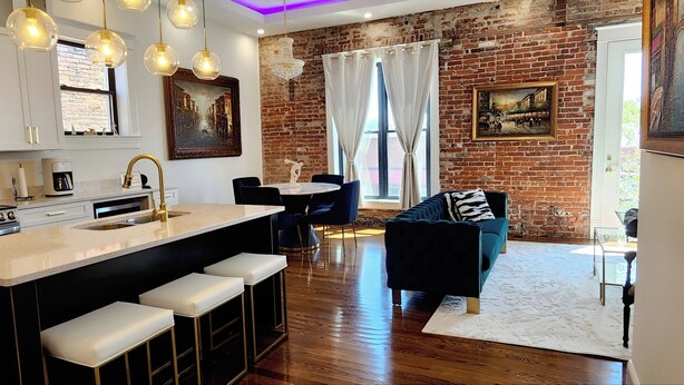 A modern kitchen with a central island, bar stools, and pendant lighting. - The Luxe High Roller! 2 bed apt in Metropolis near Harrah's Casino! Pet friendly (Metropolis)