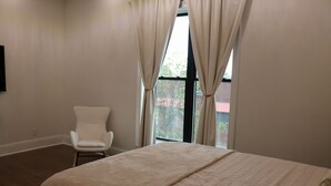 A bedroom with a bed, a chair, and a window with curtains. - The Luxe High Roller! 2 bed apt in Metropolis near Harrah's Casino! Pet friendly (Metropolis)