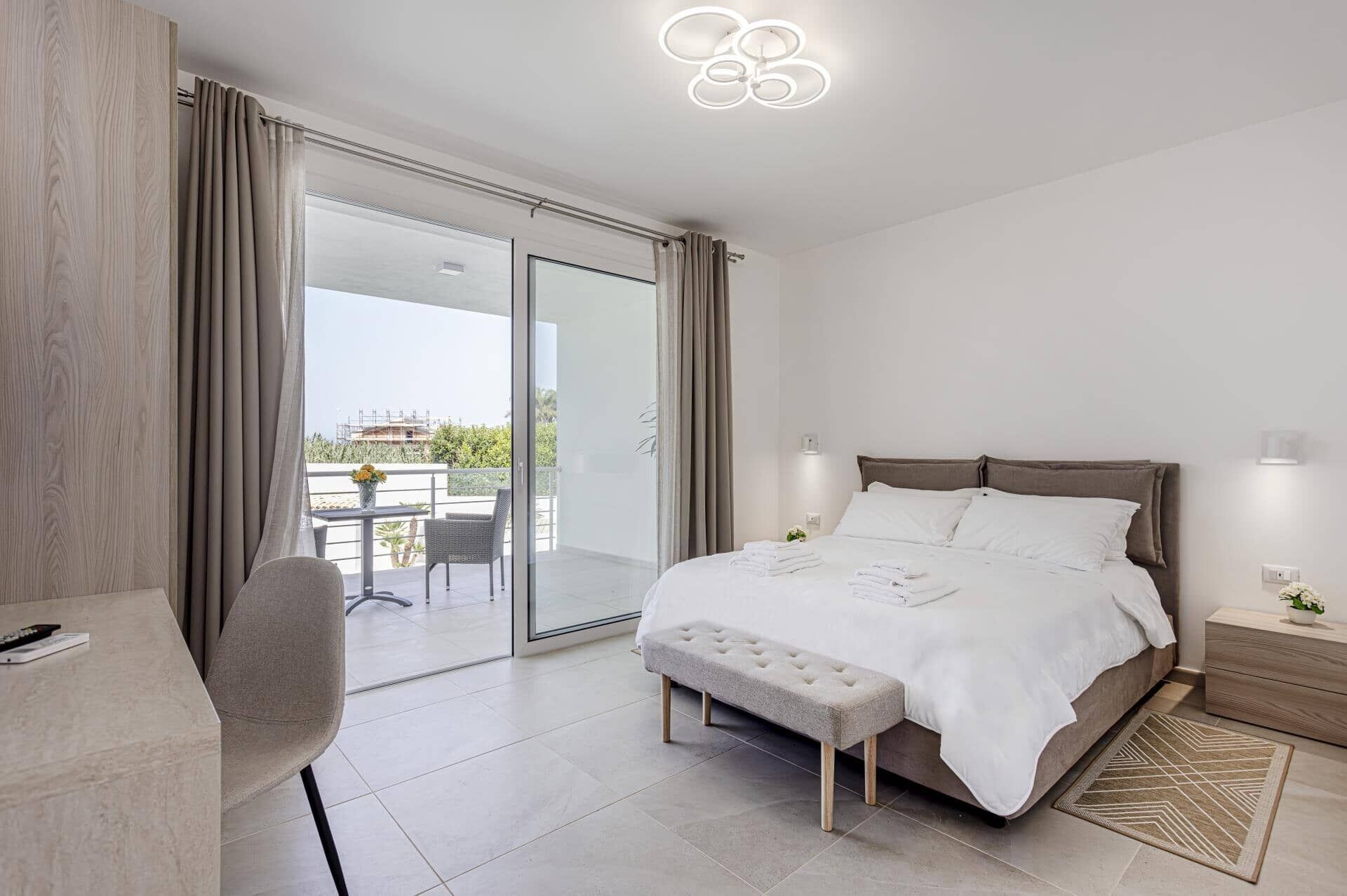 A modern bedroom with a bed, a desk, and a chair.