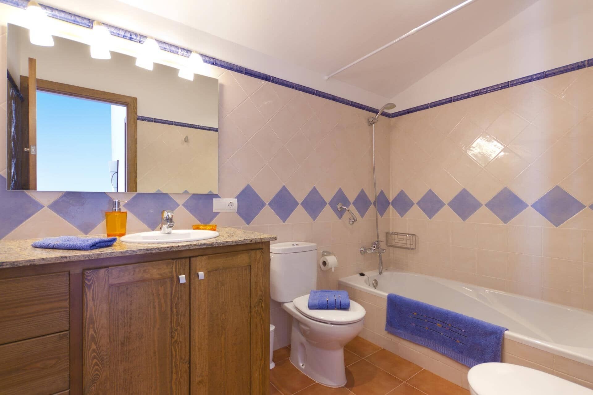 Un baño con lavamanos, inodoro y bañera.