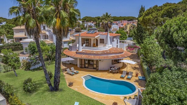 A modern villa with a swimming pool, surrounded by lush greenery and palm trees. - Villa Casa Jasmim by Villa Plus (Quarteira)