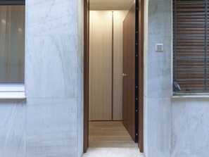 A narrow hallway with a wooden door leading to a room. - Chic and Modern Studio in Kolonaki (Athens)