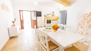 A bright, modern kitchen with white cabinets, a built-in oven, and a large window. - Villa Trullo Famigiu by Villa Plus (Grottaglie)