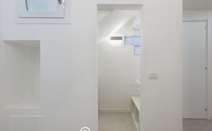 A hallway with a door leading to a bathroom, a small window, and a light switch. - B Room - Studio Apartment, Sleeps 2 (Cagliari)