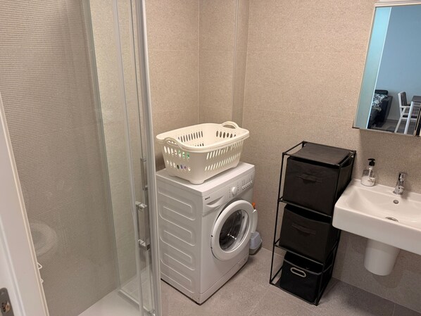 A compact bathroom with a washing machine, a sink, and a mirror. - Penthouse Oasis beach II La zenia (Orihuela Costa)
