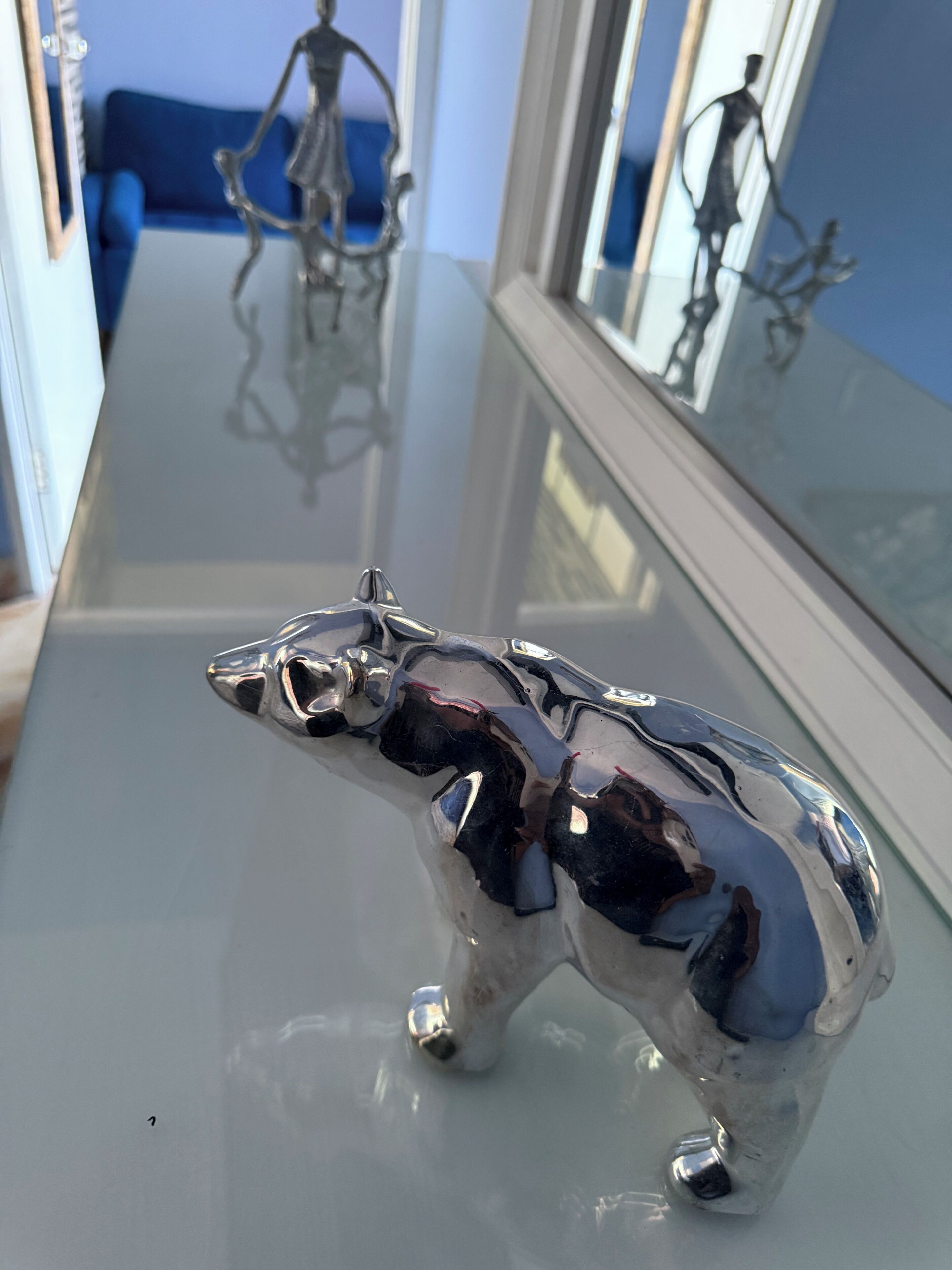 A shiny metallic bull figurine on a reflective surface.