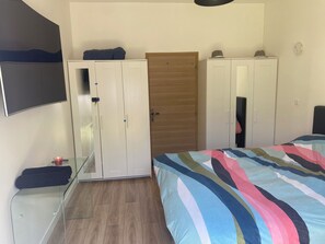 Cozy retreat with a bed, wardrobe, and mirror, perfect for a restful stay.