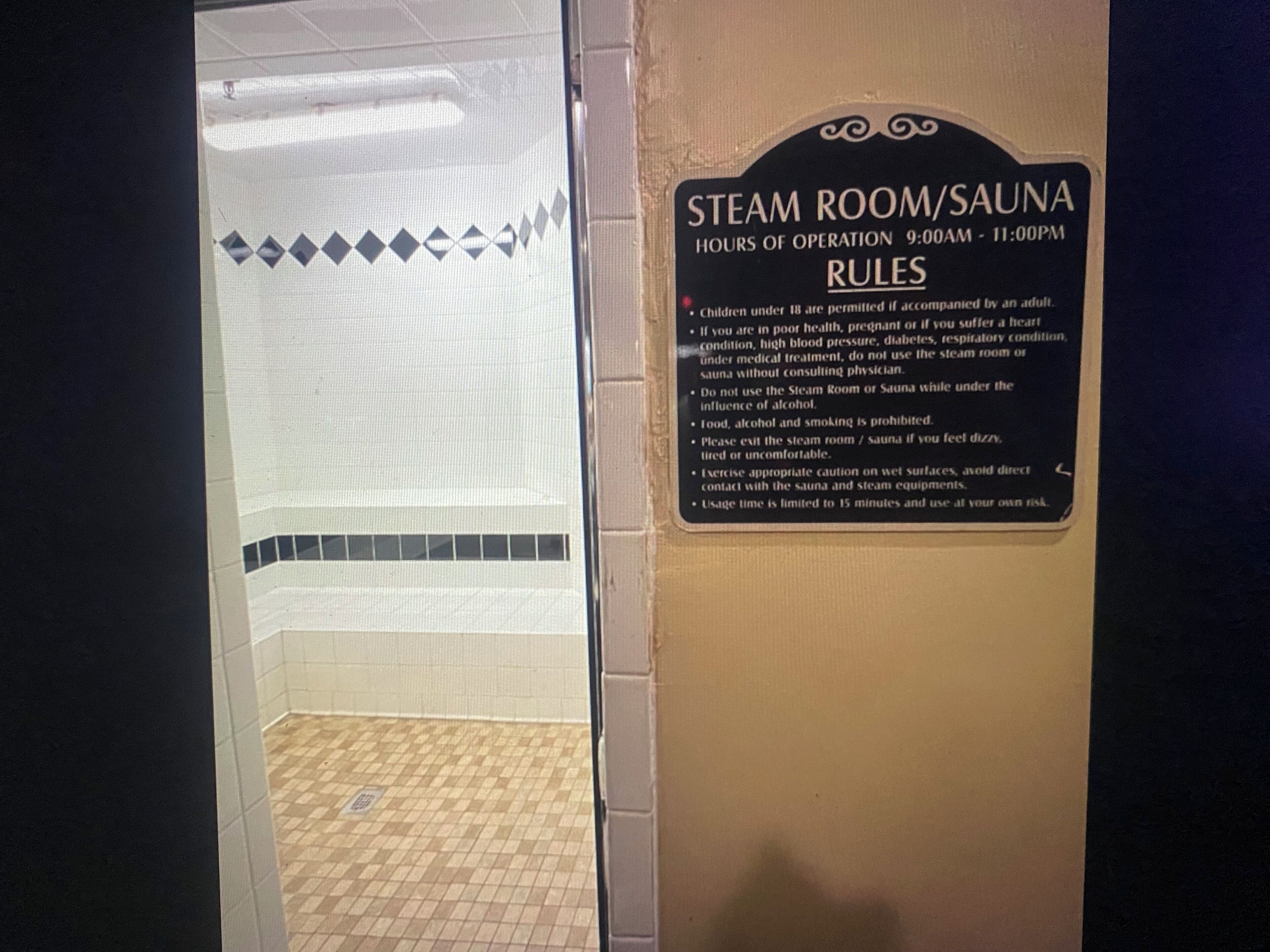 Una sauna con un cartello che indica gli orari di apertura e le regole.
