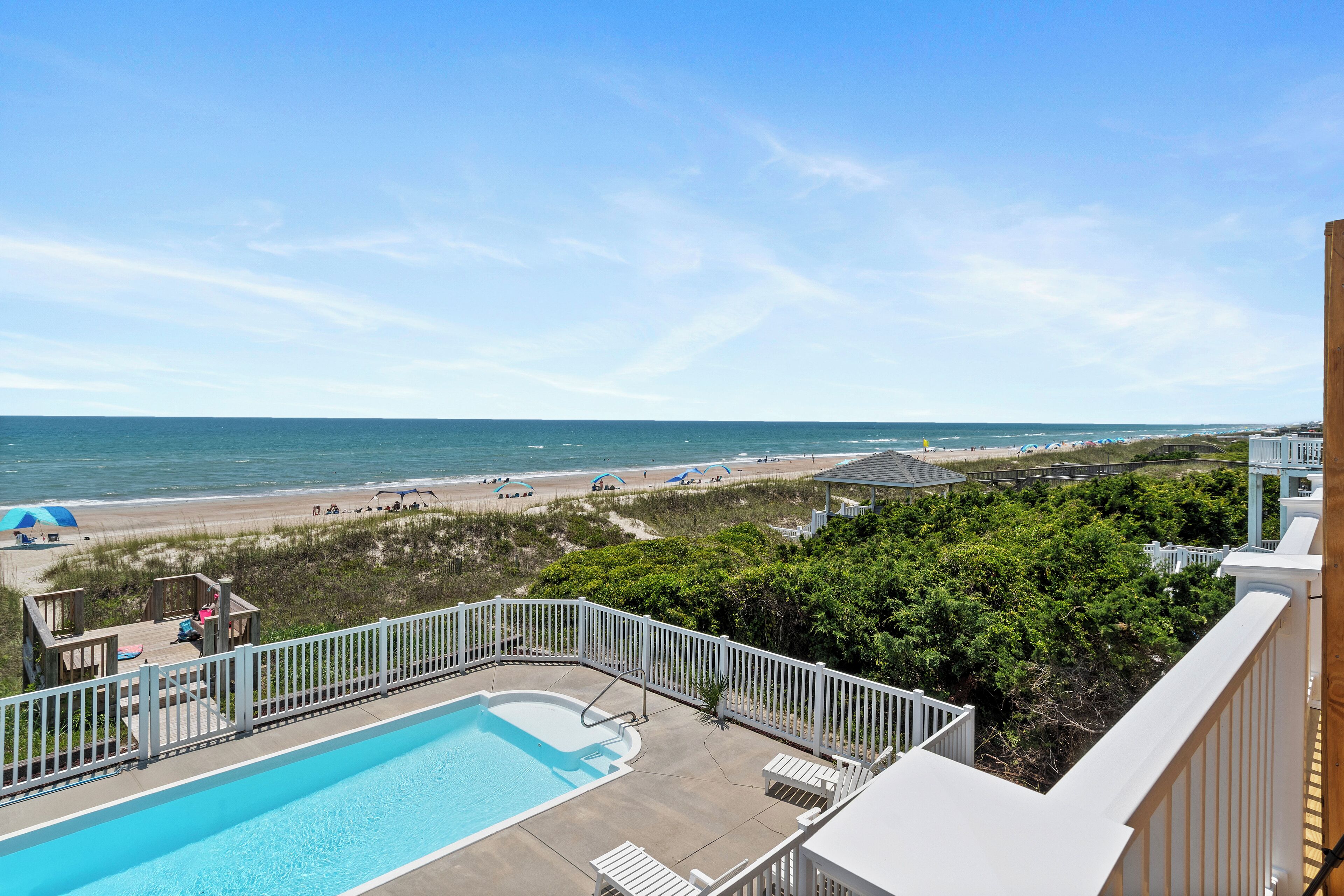 Ein Poolbereich mit Blick auf Strand und Meer.