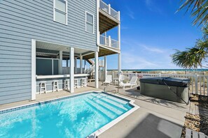 A pool area with a hot tub, outdoor seating, and a balcony overlooking the beach. - Luxury Oceanfront Home: Private Pool, Elevator Access, Game Room & More! (Emerald Isle)