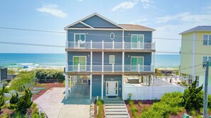 Une maison de deux étages située en bord de mer, dotée d’un balcon, d’un numéro bien visible, le « 609 », et offrant une vue sur l’océan.
