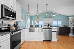A modern kitchen with white cabinetry, stainless steel appliances, and a large island. - Luxury Oceanfront Home: Private Pool, Elevator Access, Game Room & More! (Emerald Isle)