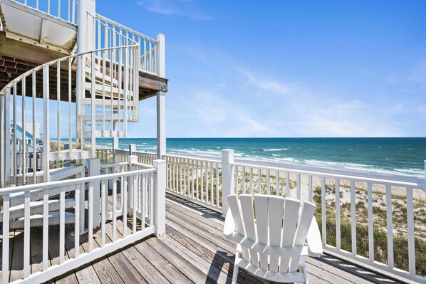 A wooden deck with white railings overlooking a beach. - Oceanfront | 2 King Suites + Pool + Pet Friendly (Emerald Isle)