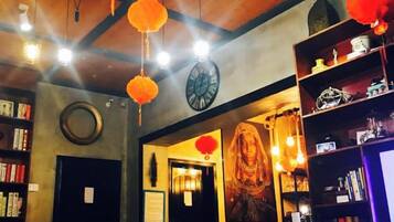 Una librería acogedora con estanterías, un reloj y adornos colgantes.