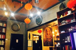 A cozy bookstore with bookshelves, a clock, and hanging decorations. - Seaside Inn (Shenzhen)