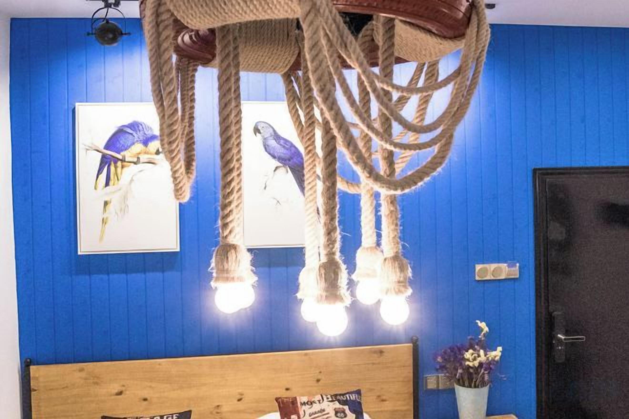 A room with a blue wall, a wooden headboard, a hanging light fixture, and a door.