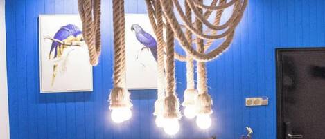 A room with a blue wall, a wooden headboard, a hanging light fixture, and a door.