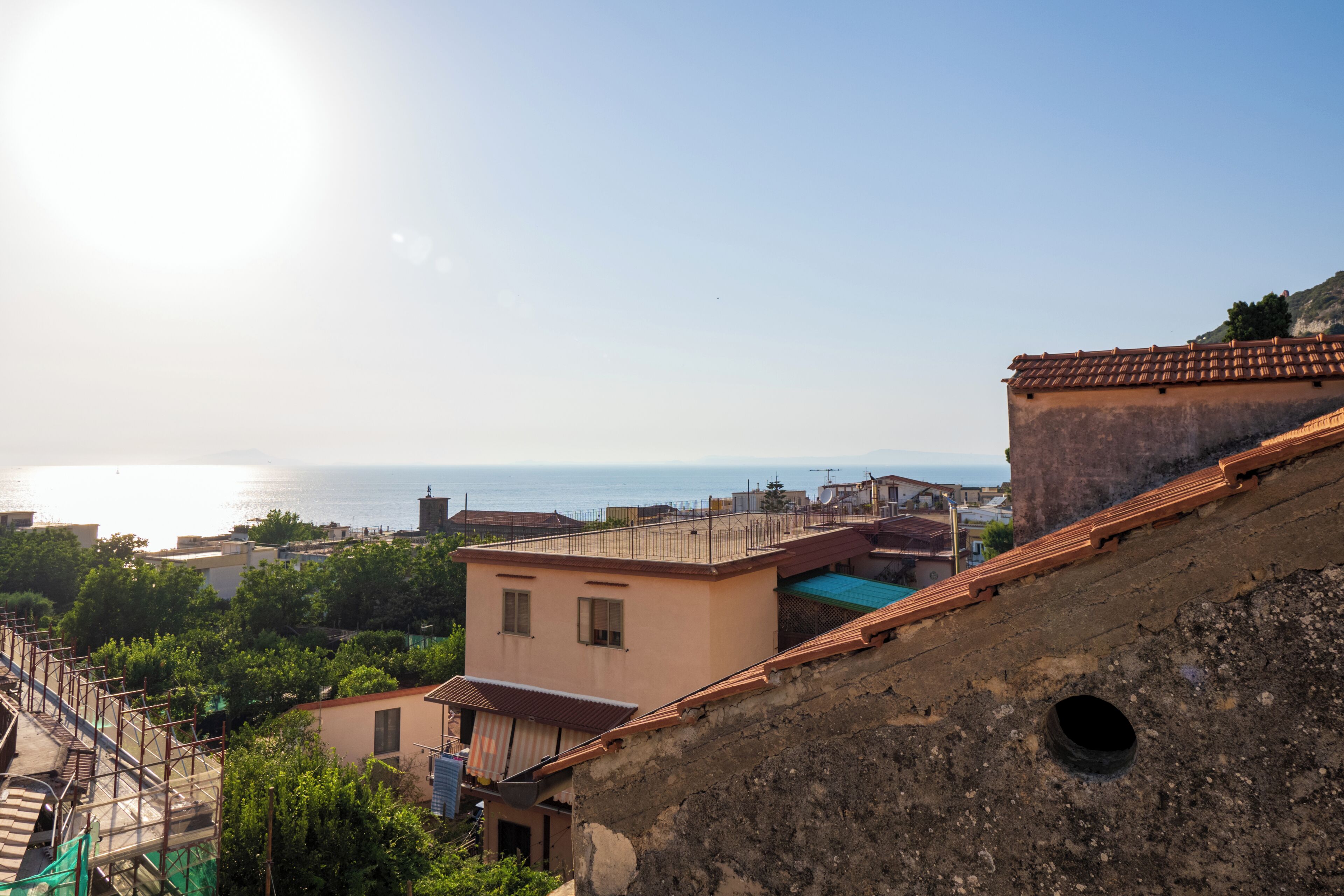 Une ville côtière avec des bâtiments, un ciel dégagé et la mer en arrière-plan.