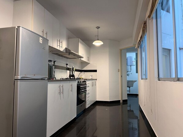 A modern kitchen with white cabinets, a built-in oven, and a gas stove. - 3bed Apt in Miraflores - Free Wifi, Free Parking (Lima)