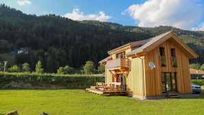 A wooden cabin with a balcony, a deck, and a view of a forested mountain. - Murau 5 - Chalet Murlaub (Murau)