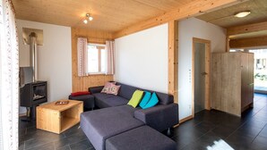 A modern interior with a sofa, a small wooden table, and a fireplace. - Murau 13 - Chalet Murau (Murau)