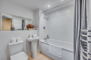 Ein modernes Badezimmer mit Toilette, Waschbecken und Dusche.