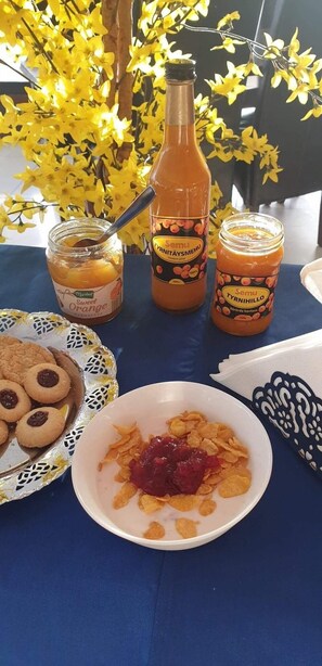 A table with jars of sweet preserves, cookies, and cereal with jam. - Skinnargården (Malung)
