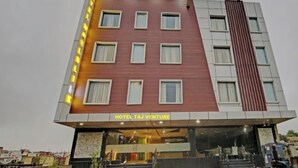 A multi-story hotel with a modern facade, featuring a prominent sign for 'HOTEL TAJ VENTURE' and a series of windows. - Charming 9-bedroom hotel with AC and WiFi in brilliant Agra (Agra)