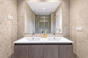 Deluxe appartement | Badkamer | Een haardroger, handdoeken, zeep, shampoo
