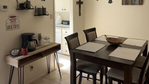 A dining area with a table, chairs, a coffee station, and wall decorations including a cross and a coffee sign. - NEW LISTING Right At Home-Midland Cowboy Siesta Corner Lot w/ Patio & Cov'd Park (Midland)