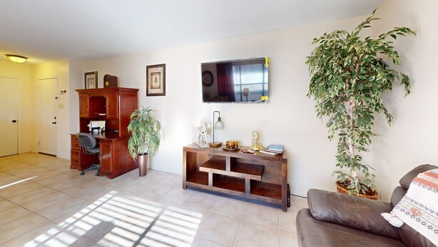 A living room with a brown leather sofa, a wooden coffee table, and a large potted plant. - NEW LISTING Right At Home-Midland Cowboy Siesta Corner Lot w/ Patio & Cov'd Park (Midland)