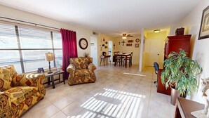 A living room with patterned sofas, a dining area, and a kitchen in the background. - NEW LISTING Right At Home-Midland Cowboy Siesta Corner Lot w/ Patio & Cov'd Park (Midland)