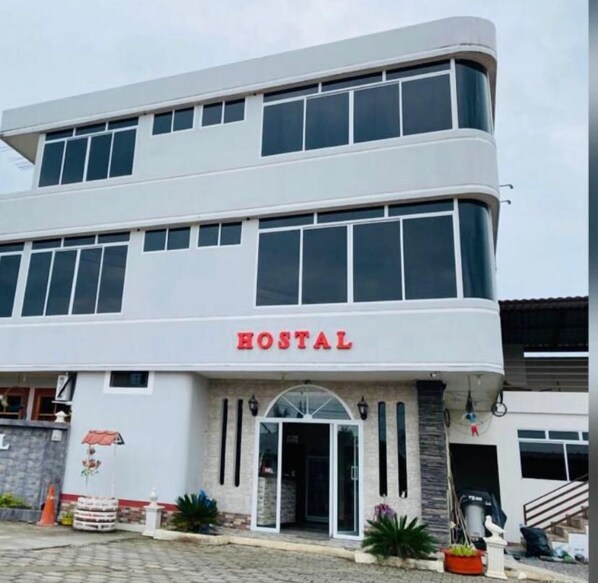 A two-story building with a sign reading "HOSTAL" at the entrance.