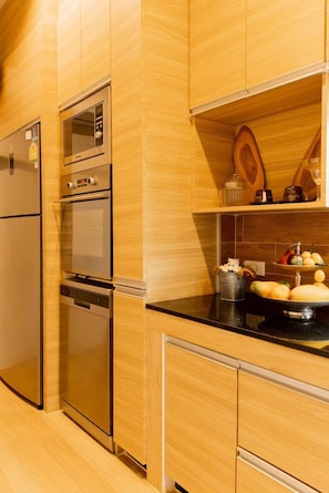 Modern kitchen with stainless steel appliances, cabinetry, and light wood finish.