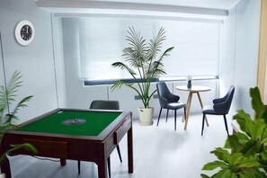 A room with a pool table, chairs, a potted plant, and a window with blinds. - Chongqing Meiyitian Boutique Hotel (Chongqing)