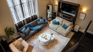 Una sala de estar con dos sofás, un televisor y una mesa de centro.