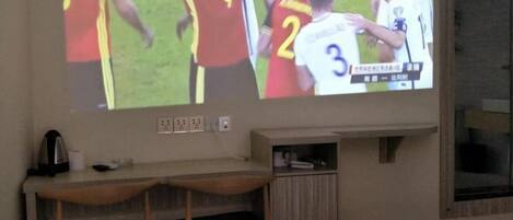 A television mounted on a wall displaying a sports event.