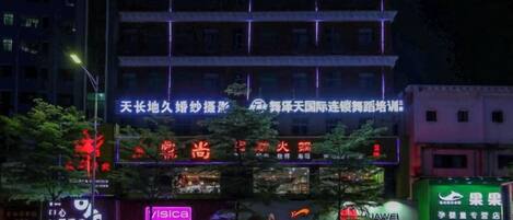 A multi-story building with illuminated signage, including a prominent OYO hotel sign.