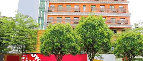 A multi-story building with a prominent OYO hotel sign, featuring a red and white color scheme.
